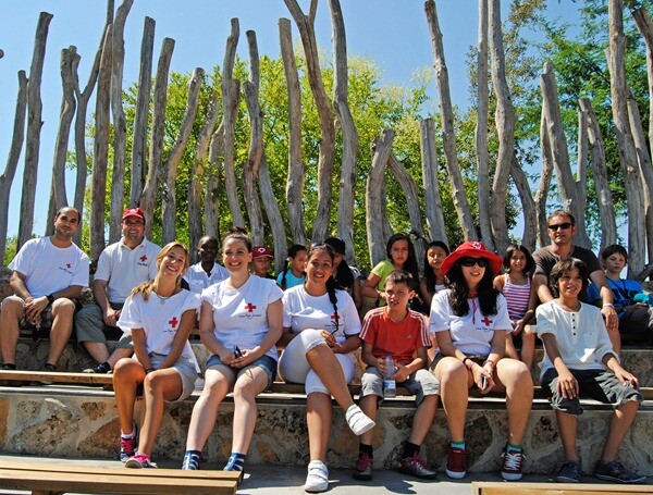 Voluntarios de la Cruz Roja junto a los niños de San Ildefonso antes de la exhibición educativa de Bioparc Valencia