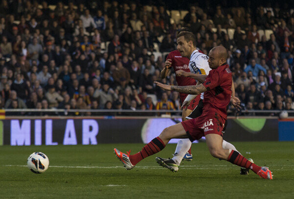 El capitán del Valencia CF dispara ante la oposición de un defensa rival. Foto: Isaac Ferrera