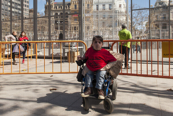 La protesta de personas discapacitadas contra la retirada de las ayudas sanitarias protagonizó los momentos previos a la mascletà. Foto: Isaac Ferrera.