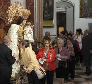 Un mujer besa la mano de la imagen Peregrina de la Virgen de los Desamparados/alberto saiz