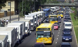 A la izquierda, comitiva de vehículos en la procesión a San Cristóbal en la avenida del Cid