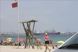 Una bandera roja prohíbe el baño en una playa Una bandera roja prohíbe el baño en una playa