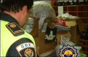 Una agente de la Policía Local de Valencia observa un grupo de fardos de prendas falsificadas en otra operación/plv