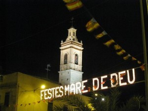 Vista de la torre de la iglesia de San Isidro con el cartel luminoso anunciando los festejos