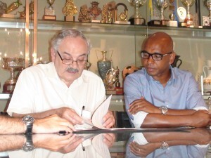 El presidente de la federación de fútbol de la C.V. y Marcos Senna firmando el acuerdo/ffcv