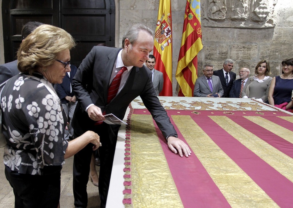 Carmen Pérez, directora del IVRC, contempla como el president toca la Real Senyera que han restaurado y cubrió el féretro de Blasco Ibáñez/gva