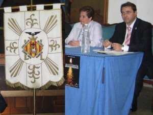 La presidenta de la Semana Santa Marinera en la presentación de un cartel de años pasados junto al estandarte y el secretario general, Mariano Pascual, de aquel año/eos