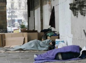 Varias personas duermen en una calle al aire libre