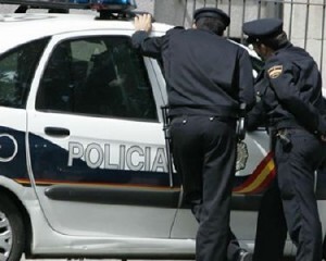Dos agentes de la policía nacional habla con un compañero de patrulla en un vehículo/cnp Dos agentes de la policía nacional habla con un compañero de patrulla en un vehículo/cnp