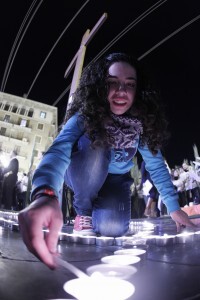 Una joven enciende una vela en la plaza de la Virgen/a.saiz Una joven enciende una vela en la plaza de la Virgen/a.saiz