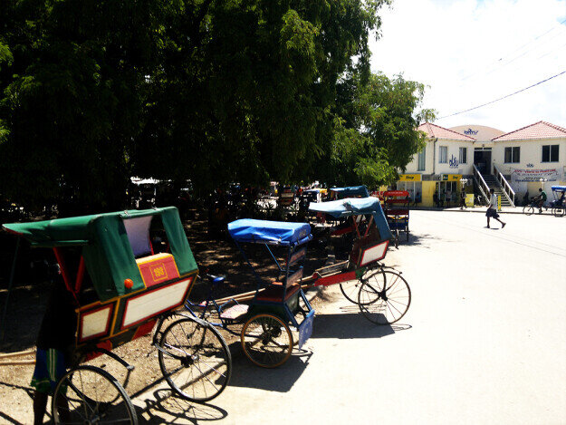 Parada de pousse pousse y ciclo pousse en el centro de Toliara descansando a la sombrica.