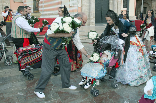 Los 'vestidors' de la Virgen recogen los primeros ramos de flores de la Ofrenda 2013. Foto: Manolo Guallart