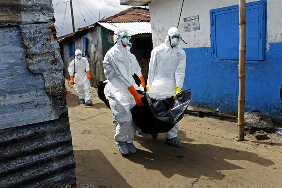 Trabajadores de la salud en Liberia recogen el cuerpo de una víctima de ébola en West Point (Monrovia)