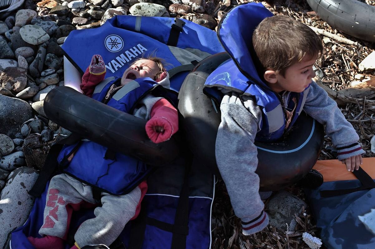 Refugees and migrants arrive at Lesbos island after crossing the Aegean sea from Turkey on October on October 29, 2015. At least seven children died when boats carrying migrants sank off Greece on October 18, as rescue workers battled to save more youngsters on the seashore in the latest desperate scenes in Europe's refugee crisis. Since the start of the year, 560,000 migrants and refugees have arrived in Greece by sea, out of over 700,000 who have reached Europe via the Mediterranean, according to the International Organization for Migration (IOM). AFP PHOTO / ARIS MESSINIS