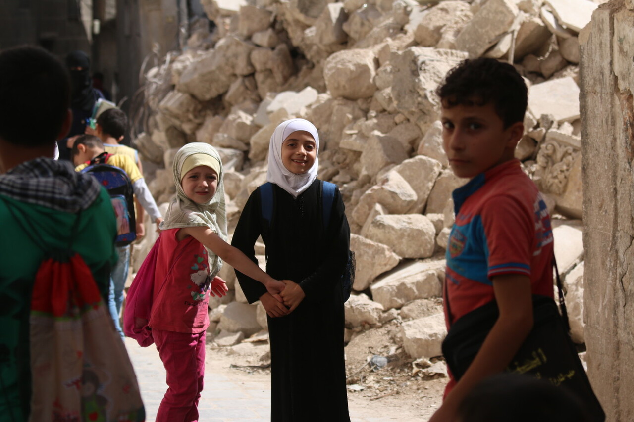 On 21 September 2016 in eastern Aleppo in the Syrian Arab Republic, Judy (white head scarf), 9, and her schoolmates return from the first day of school passing the rubble of nearby houses. I go to school every day, except for the times when I hear the planes, Judy explains. I want the road to reopen so I can go see my brother who lives in another city and just got married. I havent even met his wife yet, says Judy. Instead, the road remained closed due to heavy bombardment and shelling. In Judys neighborhood, electricity is largely unavailable as there is a fuel shortage. One in four schools are not functioning in the Syrian Arab Republic because they have been damaged, destroyed, or serve as shelters for displaced families or are in use for military purposes. Over two million children across the country are not able to go back to learning, while another 400,000 children are at risk of dropping out, due to heavy violence, lack of safe learning environments and displacement. More than 52,000 teachers have left their jobs. Two decades of investment in learning has been wiped out, as some children have lost up five years of their education, while others have never been to school. UNICEF is supporting more than 1,200 dedicated young volunteers to conduct a door-to-door campaign to map the numbers and situations of out-of-school children, while reaching out to parents with information about the simplified school enrollment processes and the right to have an education. Also recently launched is a back-to-learning campaign that aims to reach 2.5 million children in the country, including 154,000 living in besieged and hard-to-reach areas. UNICEF will be providing educational materials, school bags and stationery. A social mobilization campaign encourages parents to send their children to school or benefit from alternative learning opportunities where schools are no longer functioning. As part of that campaign, social media, radio and televi