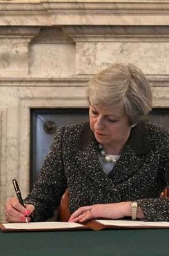 Theresa May realizando la firma del Brexit. (Imagen-BCC).
