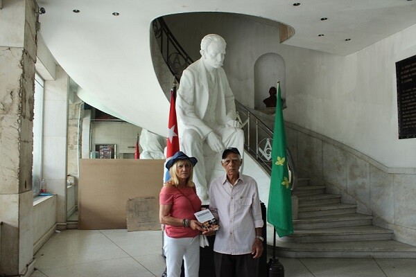 Conxa Pradera haciendo entrega de un ejemplar de `Cada mirada es única` en la Biblioteca de La Gran Logia de Cuba.