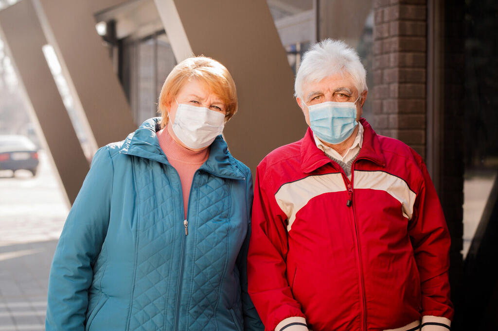 An elderly couple of people in protective masks. Coronavirus Protection Concept