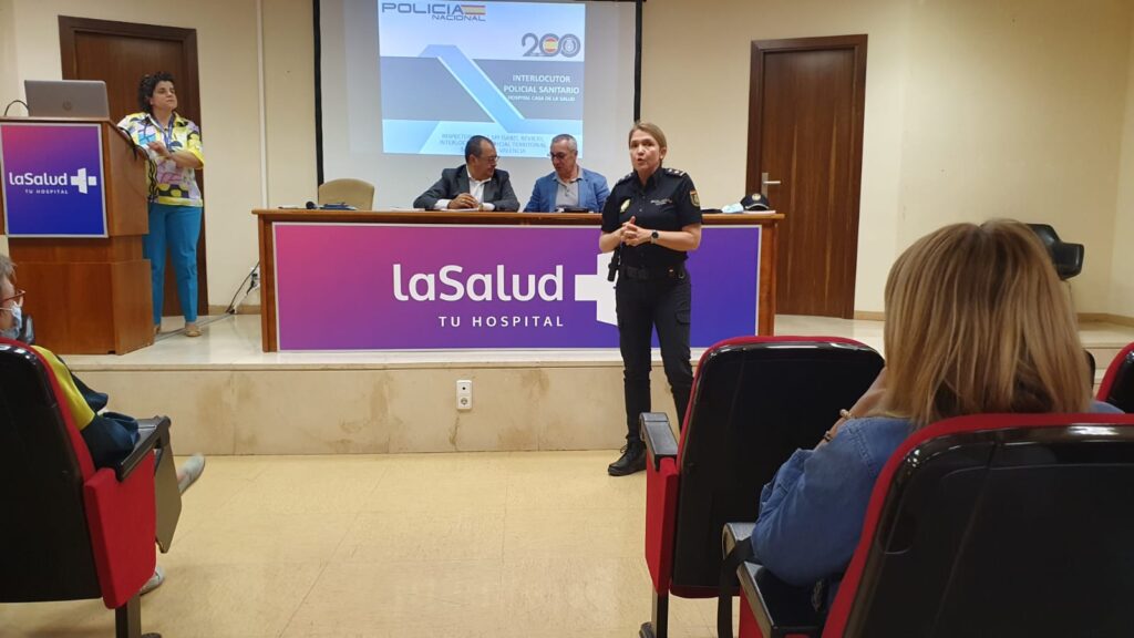Un grupo de personas frente a una mesa con una maleta de viaje Descripción generada automáticamente con confianza media