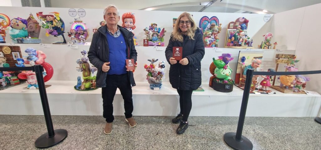 La V edición del Premio El Camino del Santo Grial reconoce el ninot infantil “Un bosc de llibres” de la Falla Ramiro de Maeztu – Els Lleons 3 Don Jesus Jimeno Peris y la Dra. Ana Mafe Garcia con el ninot premiado de la Falla Ramiro de Maeztu Els Lleons Mediana